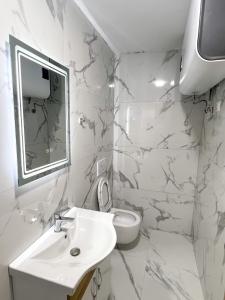 a white bathroom with a sink and a toilet at Villa Osmani in Shkodër +30 photos