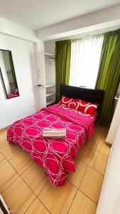 una camera da letto con un letto con un piumone rosso di I Relajante Habitación en Miraflores Central a Lima