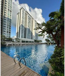 a large swimming pool in a city with tall buildings at Meridin bayvue Sierra Perdana Masai in Johor Bahru +5 photos