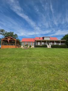 a large house with a green field in front of it at Lake House in Phil Campbell