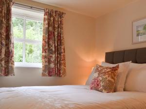 a bedroom with a bed and a window at Honeysuckle Cottage - Uk4177 in Mayfield +5 photos