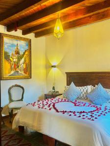 a bedroom with a bed with a red flower on it at Hotel Casa Rosario in San Miguel de Allende