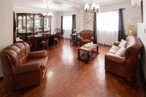 a living room with leather furniture and a dining room at A Casa do Navio in Capelas