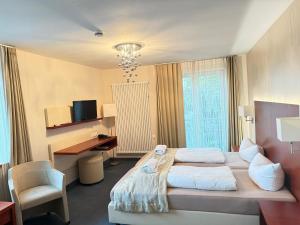 a hotel room with a bed and a desk at Krone Langenburg by Ammesso in Langenburg