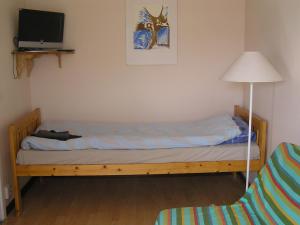 Bett in einem Zimmer mit einer Lampe und einer Couch in der Unterkunft Fredrika Hotell Jakt&Fiskecamp in Fredrika