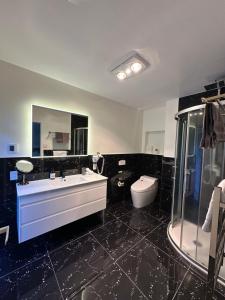 a black bathroom with a sink and a toilet at Rotorua Luxury lakeside Resort in Rotorua +64 photos