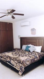 a bedroom with a bed with a ceiling fan at La Familia Chicxulub Beach Penthouse in Chicxulub +33 photos