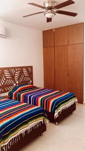 two beds sitting next to each other in a bedroom at La Familia Chicxulub Beach Penthouse in Chicxulub