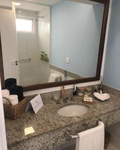 un bagno con un lavandino e un grande specchio di Buzios Beach Resort a Búzios