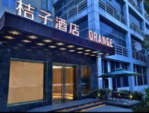 un ingresso di un hotel con un'insegna al neon arancione di Orange Hotel Beijing Yizhuang Rongjing West Street a Pechino
