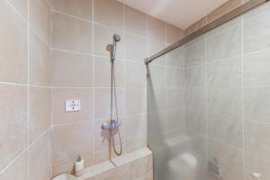 a bathroom with a shower with a shower head at RedDoorz Plus at Hotel Ulin Samarinda in Samarinda