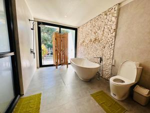 a bathroom with a bath tub and a toilet at Casa Nemo Beach Resort & Spa in Sabang +121 photos