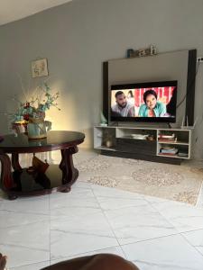 a living room with a tv and a coffee table at Paradise stay villa #1 in Breadnut Hill