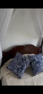 Una cama con una almohada azul encima. en Epona, en Marcos Paz
