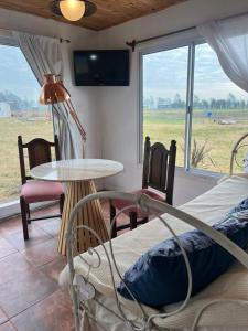 Una habitación con dos camas y una mesa y una ventana. en Epona, en Marcos Paz