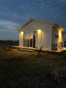 Una pequeña casa blanca con luces en el lateral. en Epona, en Marcos Paz 7 fotos más