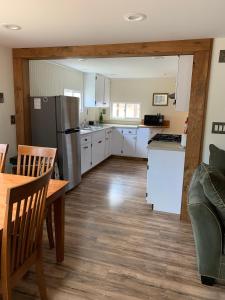 - une cuisine avec des placards blancs, une table et un réfrigérateur dans l'établissement Green River Cottage, à Guilford 31 autres photos