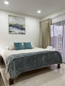 Un dormitorio con una cama grande frente a una ventana. en Los Ángeles, en Fortuna
