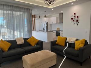 a living room with two couches and a kitchen at Jack Adamson Retreat in Twizel