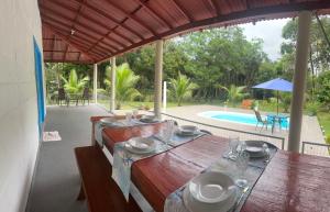 comedor con mesa y piscina en Eco sitio Casa da Mata, en Curuçá