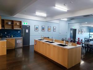 a kitchen with blue walls and a counter with sinks at Urbanz in Christchurch