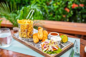 a tray of food with onion rings and fries on a table at Tanoa Waterfront Hotel in Lautoka