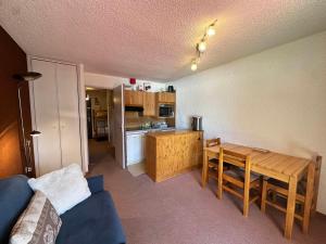 a living room with a table and a kitchen at Studio cabine 27m² au pied des pistes de luge, balcon sud, navette gratuite - FR-1-515-236 in Villard-de-Lans