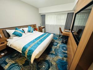 a bedroom with a large bed with blue pillows at The North Garden Hotel Beijing Wangfujing in Beijing