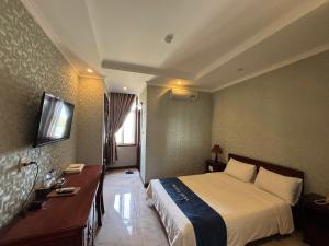 a hotel room with a bed and a television at LENA HOTEL in Danang