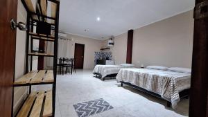 une chambre avec deux lits et une table et des chaises dans l'établissement Apart puesta del sol Iguazú, à Puerto Iguazú 64 autres photos