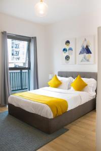 - une chambre avec un lit doté de draps jaunes et une fenêtre dans l'établissement Bright&spacious 2bd Yas Island, à Abu Dhabi