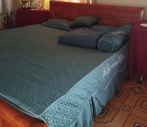 a large bed with blue sheets and pillows on it at Thaivu homestay in Háº£i Háº­u