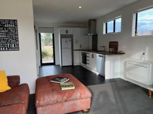 a living room with a couch and a kitchen at Glen Lyon Road in Twizel