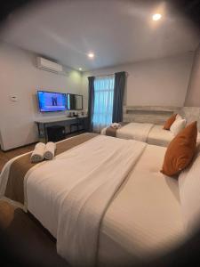 クアンタンにあるThe Leverage Lite (Kuantan)のテレビ付きのホテルの部屋にベッドが2つある