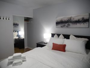 a bedroom with a white bed with a red pillow at Entire Unique Apartment in Kingston