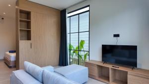 a living room with a couch and a flat screen tv at Sefirot Studios in Kuta Lombok