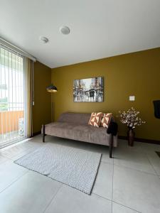 a bedroom with a bed and a green wall at Lovely Apartment near Costa Rica airport in Heredia