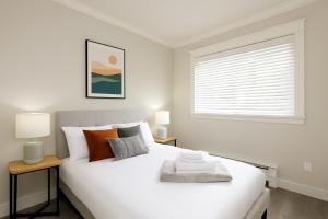 una camera da letto bianca con un grande letto bianco e una finestra di Spacious 4BD Home in Vancouver a Vancouver
