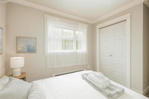 una camera da letto bianca con un letto e una finestra di Spacious 4BD Home in Vancouver a Vancouver