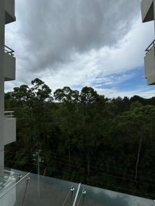 a view of a forest from the balcony of a house at Lovely Apartment near Costa Rica airport in Heredia