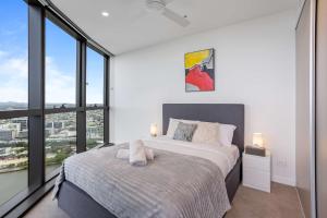 a bedroom with a bed and a large window at Your QW Escape - Pool Gym & Stunning Sky Deck View in Brisbane