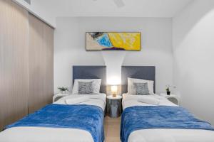two beds in a room with blue and white at Your QW Escape - Pool Gym & Stunning Sky Deck View in Brisbane