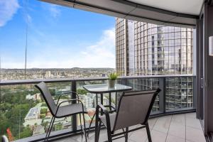 a balcony with a table and chairs and a large window at Your QW Escape - Pool Gym & Stunning Sky Deck View in Brisbane +10 photos