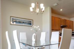 a dining room with a glass table and white chairs at New 4BR Lakeland Home with Whole-Home Water Purifier in Lakeland +12 photos