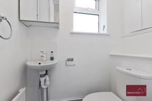 ギルフォードにあるGuildford - Two Bedroom House with Gardenの洗面台とトイレを備えた白いバスルーム +12枚の写真