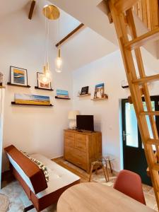 a room with a bed and a desk with a television at Logis Nature & Mer in Saint-Josse