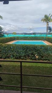 a large swimming pool with a palm tree and a fence at Palms Stars III in Chinauta