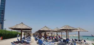 阿吉曼Luluat Alshaati的一群人坐在沙滩上的椅子上