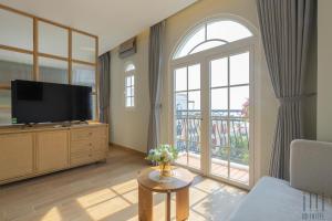 a living room with a tv and a large window at HD Hotel Sunset Town in Phu Quoc