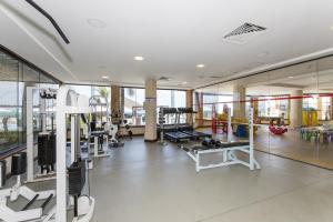 a gym with treadmills and machines in a building at Rifoles Praia Hotel e Resort in Natal